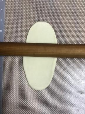 擀成长条，具体擀法是：按扁，擀面杖从中间压下去，中间向上擀，中间向下擀，大约12公分左右