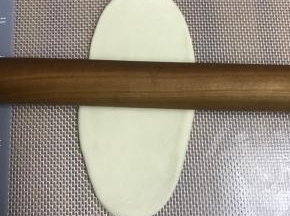 擀成长条，具体擀法是：按扁，擀面杖从中间压下去，中间向上擀，中间向下擀，大约12公分左右