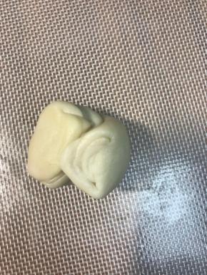 取一个面团，两端像中间对折，按扁