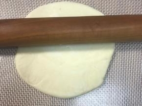 压扁剂子，中间向上一下，中间向下一下，中间向左一下，中间向右一下这样擀，如果大小不够，再来一圈，不要来回擀，面片中间厚外圈薄