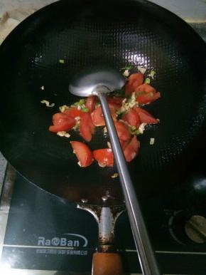炸茄子的油倒出剩点底油，爆香葱花和一半蒜末，再放入西红柿炒到软