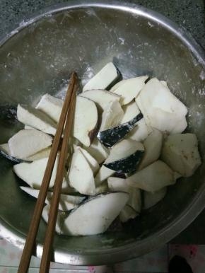 茄子切滚刀块放入盆中，撒适量干淀粉拌匀，让茄子裹匀淀粉。