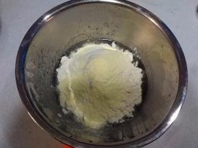 筛入面粉、奶粉拌匀，揉成团；揉好的面团盖上保鲜膜，室温静置松驰1~2个小时；