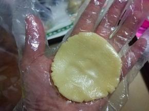 取一面团放在手掌中压成中间薄，周边厚的圆形面片;