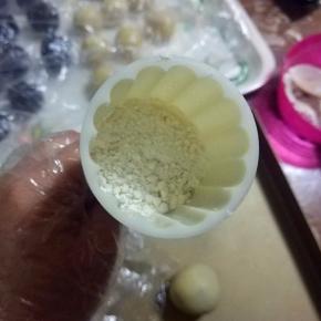 月饼模子内倒适量面粉晃一圈，接着将多余面粉倒出；