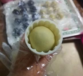 将月饼稍微搓细一圈，以免扣月饼模子时刮破表皮，放入模子内；