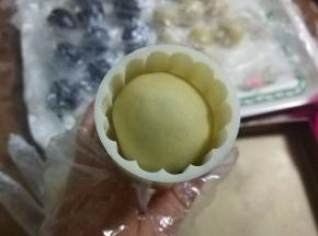 将月饼稍微搓细一圈，以免扣月饼模子时刮破表皮，放入模子内；
