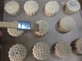 刷子沾上蛋液，然后再将刷子放碗边，按去多余的蛋液。在月饼表面薄薄刷上一层蛋液，不能刷太多，要不烤好月饼花纹模糊。放回烤箱，烤到月饼表面金黄，月饼侧面鼓起即可。
    月饼冷却后，装保鲜盒或保鲜袋里，放至四到五天回油后享用。