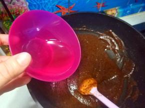 开中小火炒制枣泥，要不停的搅动枣泥，玉米油分三次加入炒制。每次油跟枣泥完全融合后，再加入剩下的油；