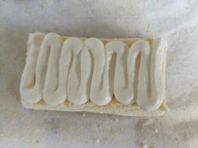 挤在蛋糕片上，四块蛋糕片叠加在一起。