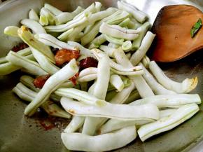 肉上色以后放葱花、姜片、大料、花椒面、李锦记生抽。放入芸豆继续翻炒。