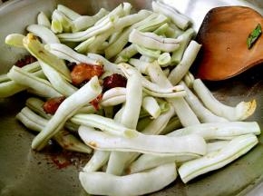 肉上色以后放葱花、姜片、大料、花椒面、李锦记生抽。放入芸豆继续翻炒。