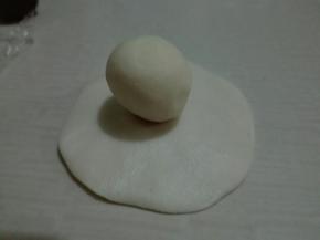 用一个水油皮擀成四周薄，中间厚的圆片，包入一个油酥