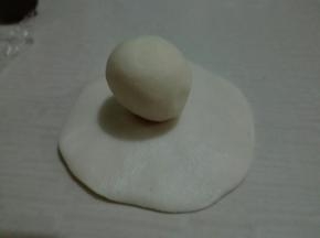 用一个水油皮擀成四周薄，中间厚的圆片，包入一个油酥
