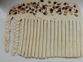 上面撒上核桃碎和蔓越莓，下面部分切成均等24个长条，每三条编成一个辫子