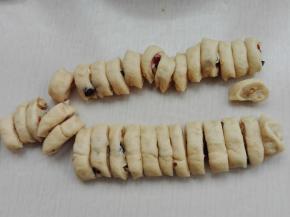 其余面团擀成长方形，撒上核桃碎，蔓越莓卷起来，切成小块