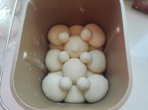 再包两个摆放中间，稍大点的面团分别等分七份，分别做耳朵，腿，鼻子，用牙签固定，面包机选择发酵，时间45分钟