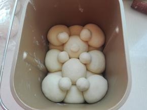 再包两个摆放中间，稍大点的面团分别等分七份，分别做耳朵，腿，鼻子，用牙签固定，面包机选择发酵，时间45分钟