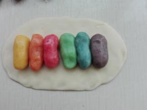 取一个水油皮面团擀成长方形，分别取一个颜色油酥并列排放好，如图