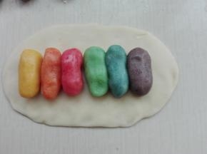 取一个水油皮面团擀成长方形，分别取一个颜色油酥并列排放好，如图