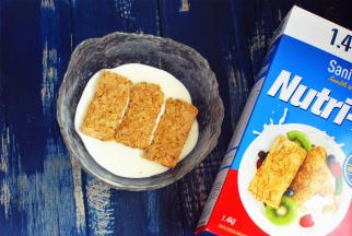 将200克浓酸奶倒入大碗里，放上3片新康利燕麦片。