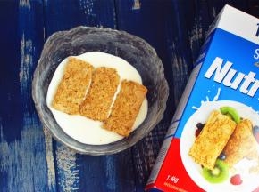 将200克浓酸奶倒入大碗里，放上3片新康利燕麦片。