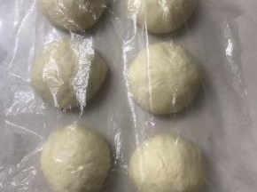 轻拍面团排气，平均分成六份滚圆，盖上保鲜膜松弛15 分钟。