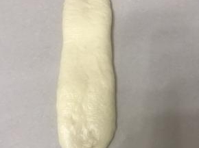 继续擀成长舌型。宽度比吐司盒底部小1.5 公分左右。