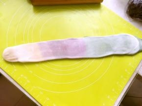 将松弛好的面团顺着长条的方向，再次擀成长条，之后卷起来
