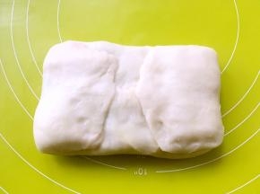 之后将水油皮材料掀起对捏，包裹上油酥皮材料，收口捏紧