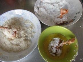 然后先在干淀粉中沾一层，再过蛋液，最后沾一层面包糠