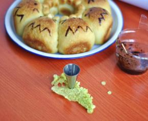 12、出炉后冷却，用融化的巧克力画上龙猫的嘴巴、胡子，用圆形裱花嘴在白菜叶刻出小圆点做眼睛，中间点上巧克力做眼球