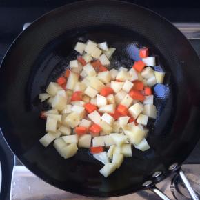 锅内放油，温后放入土豆和胡萝卜丁翻炒