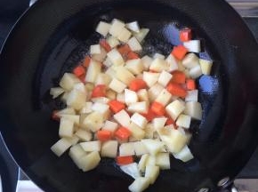 锅内放油，温后放入土豆和胡萝卜丁翻炒