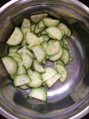将切好的黄瓜片放入盆中。