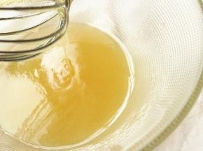 转化糖浆用手抽搅拌几下，会变得略微稀一点。加入玉米油，继续打发几下。能够缓缓滴落的状态。