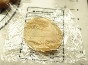 饼皮按扁，用两层保鲜膜包着，擀开成比较薄的片。