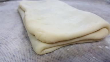 8.用擀面杖擀开，折一个三折。