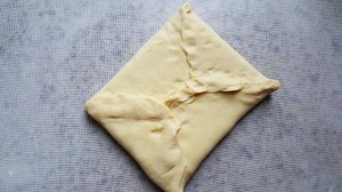 7.捏好面团的四个边，把豆沙馅包在面团中间。