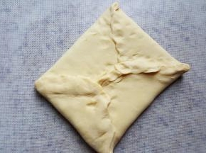 7.捏好面团的四个边，把豆沙馅包在面团中间。