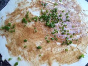 面团擀成薄片，刷上油酥撒上香葱