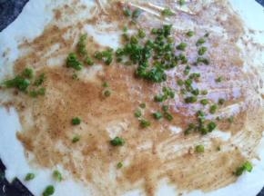 面团擀成薄片，刷上油酥撒上香葱