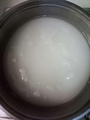 用一不锈钢煮锅，倒入水470克，再加入1000克的细砂糖，中火加热，用筷子不停的搅拌至糖全部溶化