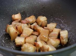 把焯过血沫的肉块放进去，翻炒上色，边炒边用锅铲按压，使五花肉里的油脂逼出去一些；