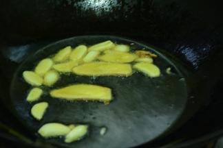 锅里倒入适量的菜籽油，等油熟烫之后加入姜蒜片炒香。
