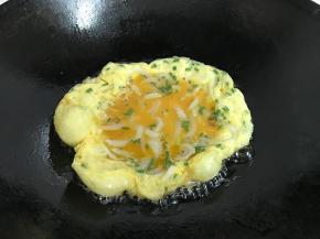 把搅匀的蛋液倒入锅中。