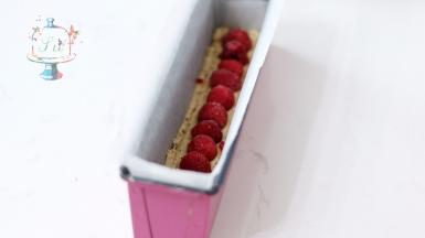 拌好的面糊装入裱花袋，先将底部铺满，正中位置摆放上覆盆子，不要按压。然后将剩余面糊均匀挤在模具中。最后轻磕震盘，让面糊可以填充满模具。放入预热好的烤箱，中层，165℃烘烤45分钟