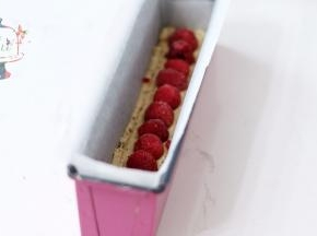 拌好的面糊装入裱花袋，先将底部铺满，正中位置摆放上覆盆子，不要按压。然后将剩余面糊均匀挤在模具中。最后轻磕震盘，让面糊可以填充满模具。放入预热好的烤箱，中层，165℃烘烤45分钟