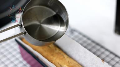 糖浆部分材料混合，煮开。取30g，均匀淋在蛋糕体上。待蛋糕体吸收后连同油纸取出剥离，放置在晾架上晾凉