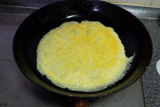 平底锅上火，放上适量食用油，把蛋液倒进平底锅里，转动平底锅，摊成一张鸡蛋皮；